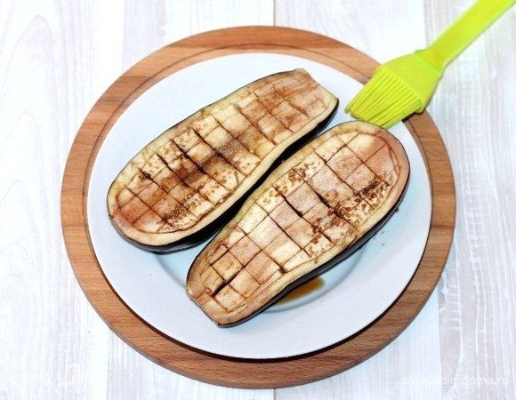 Смазываем мякоть баклажана соевым соусом смешанным с 1 ст. л. растительного масла. Кладем половинки баклажана в формочку для запекания. Затем ставим форму в предварительно нагретую до 190°С духовку на 15-20 минут. Запекать баклажан можно и в микроволновке.