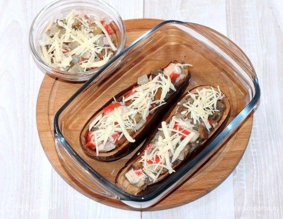 Заполняем начинкой половинки баклажана. Посыпаем начинку тертым сыром и отправляем в духовку до окончательного запекания, где то 15-20 минут.