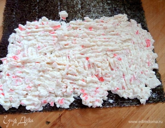 Нанести начинку на лист нори.