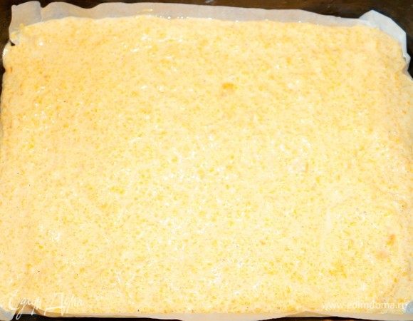 Противень застелим бумагой для выпечки, чуть-чуть смажем ее растительным маслом и выльем получившуюся морковно-творожную массу. Выпекать корж в разогретой до 180°с духовке, около 15 минут.