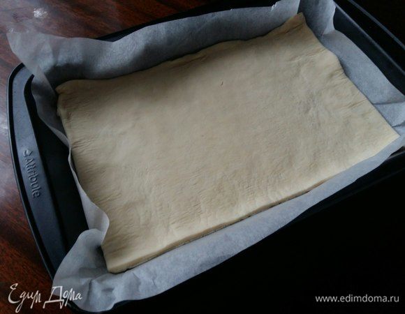 Застелить противень (у меня форма 20x30 см) пергаментом. Выложить тесто на пергамент. Я просто растянула его руками по всей форме.