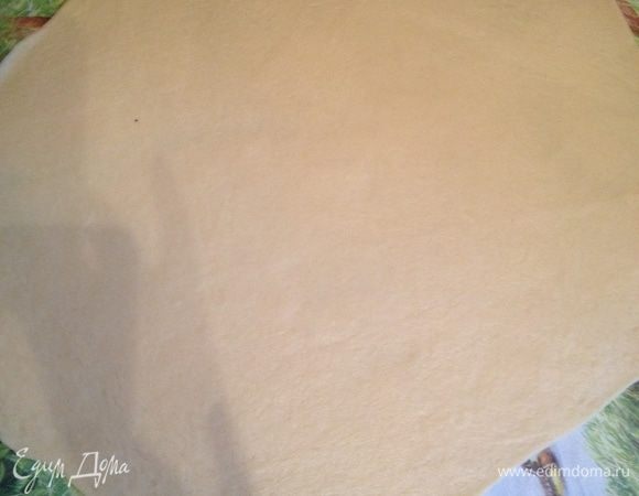 На тесто выложите маковую начинку и заверните в виде рулета.
Приготовьте противень, выложите бумагу для выпечки, смажьте сливочным маслом и перенесите на противень рулет.