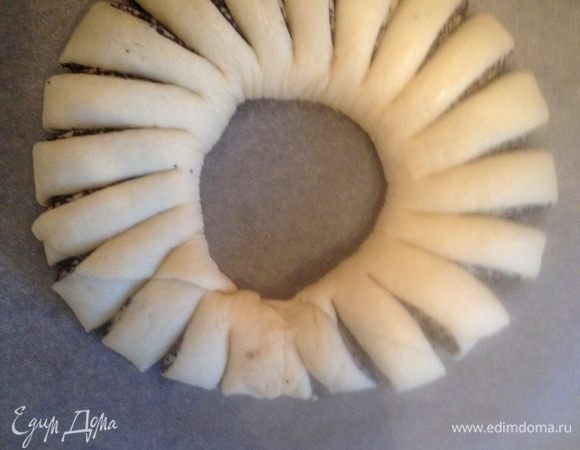 Концы скрепите между собой. Ножом делайте надрезы по кругу.
Смажьте растопленным сливочным маслом и дайте постоять в тепле 30 мин.
