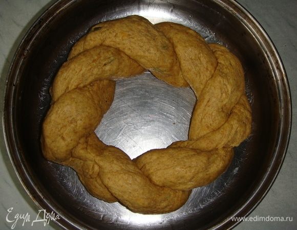 Разделить тесто на две части. Скатать колбаски и переплести их между собой, концы соединить. Выложить в смазанную маслом форму и оставить в теплом месте на 20 минут.