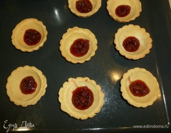 Корзиночки выставить на противень. Положить в каждую по чайной ложке джема.
