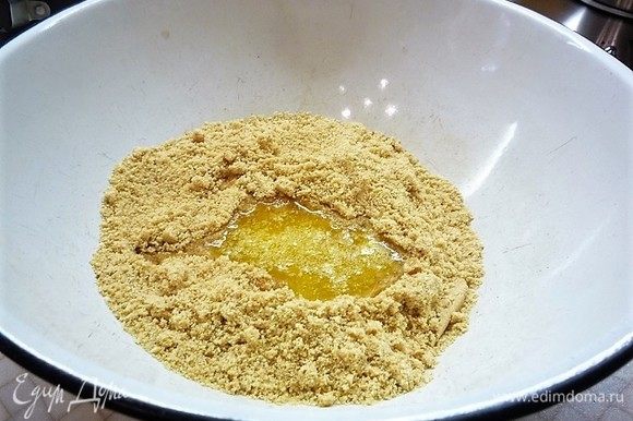 Печенье измельчаем в мелкую крошку, добавляем растопленное сливочное масло и перемешиваем.