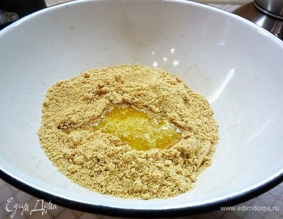 Печенье измельчаем в мелкую крошку, добавляем растопленное сливочное масло и перемешиваем.