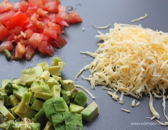 Авокадо и томат нарезаем мелким кубиком. Сыр натираем на мелкой терке.