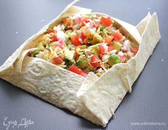 Подготовленную начинку выкладываем в центр лаваша, оставляя 3-4 см от края. Загибаем края. 