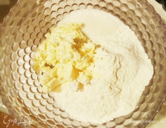 Натереть замороженное масло на крупной терке, добавить половину сахара и муку с разрыхлителем, замесить тесто.