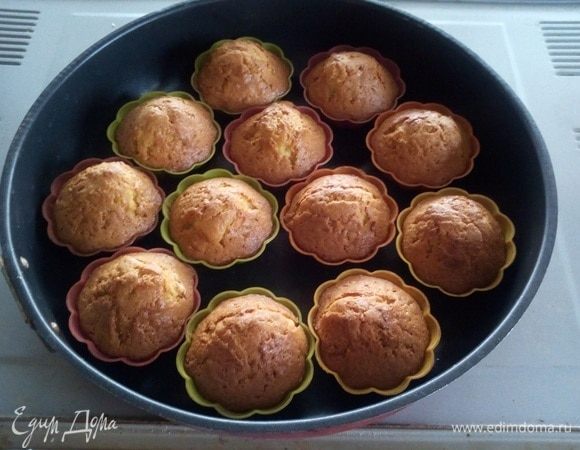 Ставим противень с формочками в разогретую духовку. Выпекаем 15-20 минут при 180°С. 
Готовим крем для капкейков. В чашу миксера выкладываем яичные белки и начинаем взбивать. Взбиваем до пиков. На огонь ставим небольшую кастрюлю, высыпаем в нее сахар и лимонную кислоту. Добавляем воду. Варим сахарный сироп с момента закипания 7 минут на медленном огне. Затем аккуратно тонкой струйкой выливаем сироп в чашу миксера к взбитым белкам. Взбиваем около 7-10 минут. Крем остужаем.