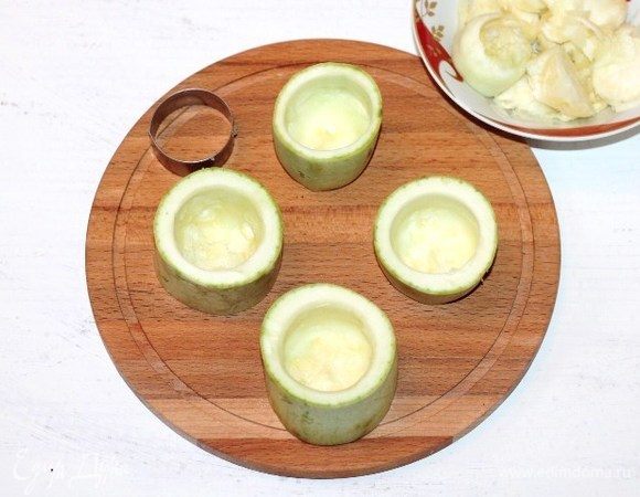 Кабачки промыть и обсушить бумажным полотенцем. У кабачков срезать плодоножку и разрезать каждый на 3 части (цилиндры). Из каждого цилиндра удаляем чайной ложкой мякоть, оставляя донышко. Получились кабачковые «стаканчики».