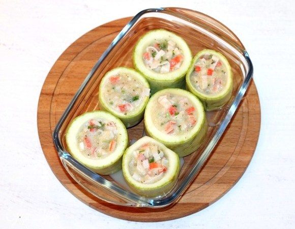 Выкладываем кабачковые стаканчики в форму для запекания и заполняем начинкой.