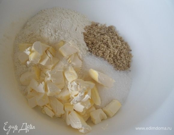 В миске смешать муку, мелкий сахар, измельченные орехи и холодное масло, нарезанное кубиками.