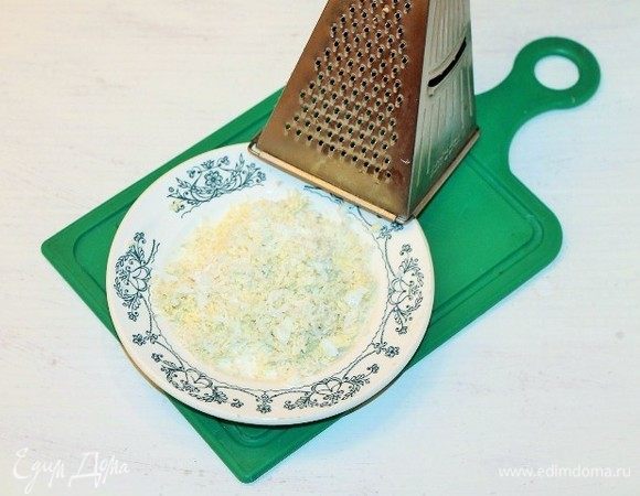 Куриное яйцо, отваренное вкрутую, очищаем от скорлупы и трем на средней терке.
