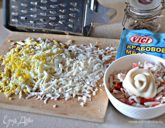 К измельченному крабовому мясу добавьте майонез. Яйцо отварить, очистить от скорлупы и натереть на терке либо мелко порубить ножом. Сыр натереть на крупной терке. Я использовала пармезан, но вы можете взять для приготовления блюда любой другой твердый сыр.