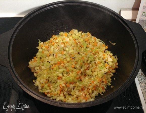 В казан, где обжаривался бекон, выкладываем сливочное масло и высыпаем все овощи. Обжариваем овощи, активно помешивая.