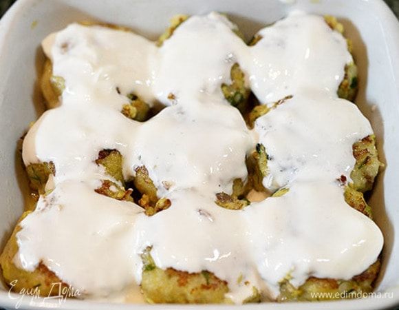 Выложите в форму, залейте сметаной.