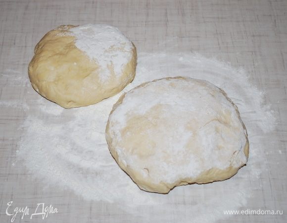 Прошел час. Тесто поднялось, делим на две части. Присыпаем мукой и раскатываем.