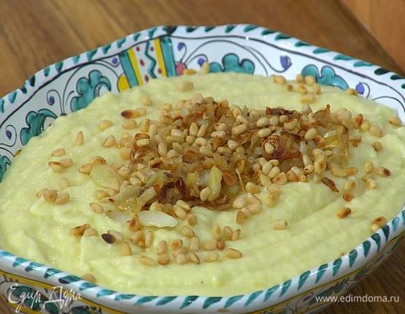 Выложить на блюдо пюре, сверху обжаренный лук с чесноком, посыпать все кедровыми орехами.