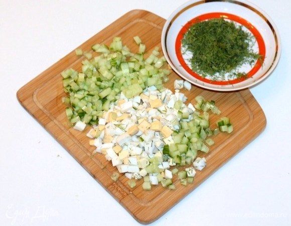 Куриные яйца, отваренные вкрутую, очистить от скорлупы. Огурец и яйца порезать кубиками. Укроп измельчить.