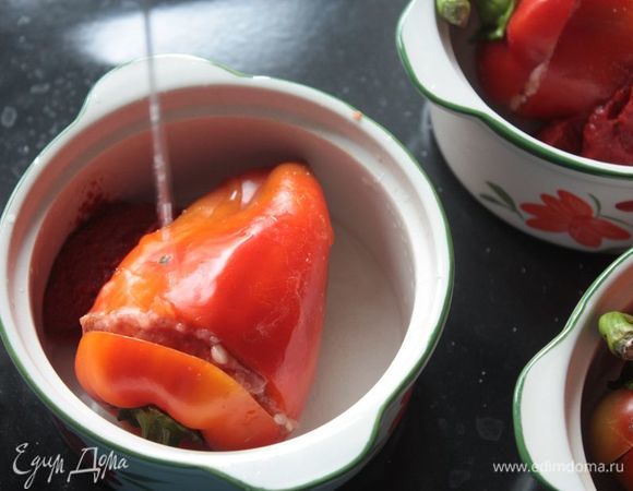 Добавьте в каждую формочку по ложке томатной пасты и половинке ложки сахара. Посолите по вкусу и залейте водой так, чтобы она покрывала перец наполовину, максимум — на 2/3. Фарш также даст сок, поэтому я не рекомендую заливать перец полностью. 