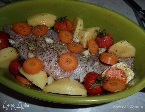 Выложите окуня в керамическую форму, вокруг выложите нарезанный картофель, помидоры черри, кружочки моркови. Сбрызните сверху оливковым маслом, посыпьте смесью перцев и розмарином.