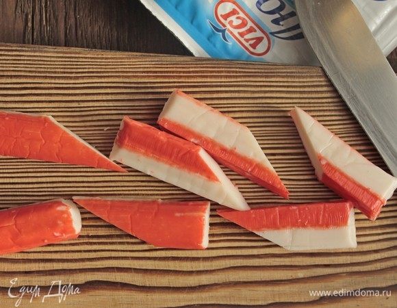 Крабовые палочки нарезать по диагонали, пополам.