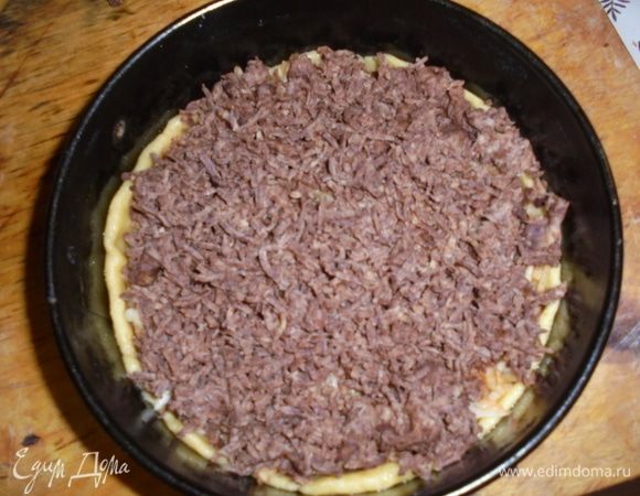 Сверху на слой яблок натереть темную часть теста.