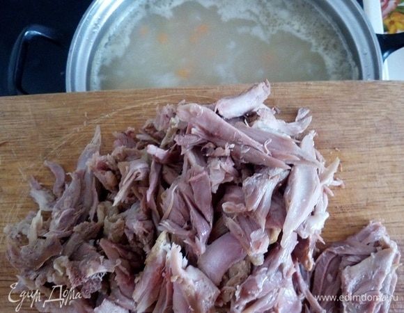 Отварное мясо разбираем на небольшие кусочки, убирая кости. Закладываем мясо в кастрюлю. 