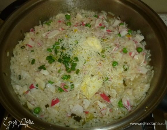 Ризотто снять с огня, вмешать сливочное масло, тертый пармезан, оставшийся лук, цедру лимона, приправить по вкусу. Остудить.