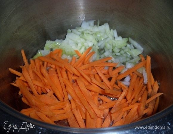 Ставим кастрюлю на огонь. Наливаем в кастрюлю растительное масло. Добавляем нарезанные лук и морковь.