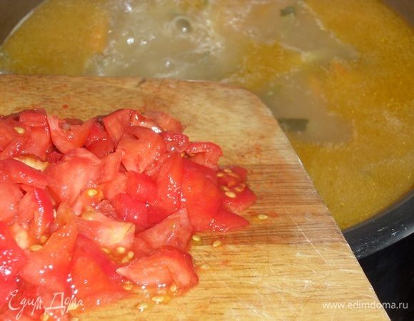 В кастрюлю с кипящим супом добавляем нарезанные помидоры и соль. Варим 2 минуты.