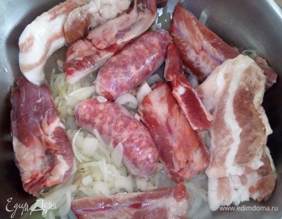 В низкую кастрюлю с толстым дном налить оливковое масло, всыпать измельченные лук и чеснок, положить сборные кусочки свинины. В моем случае это: ребрышки, свежие колбаски (salsiccia), бекон. Все пассеровать до золотистой корочки.