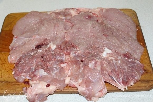 Курицу разрезать по спинке и аккуратно удалить все косточки, оставить мясо на шкурке. Мясо равномерно распределить по коже, посолить, поперчить, слегка отбить.