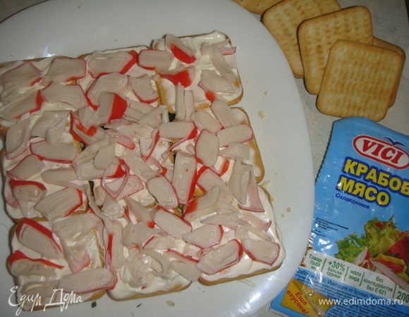 Сверху укладываем слой крекера, смазываем майонезом и выкладываем крабовое мясо.