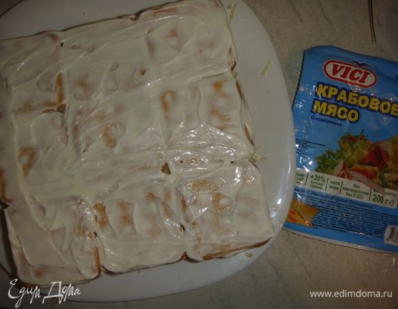 Последний слой крекера и бока салата смазываем майонезом.