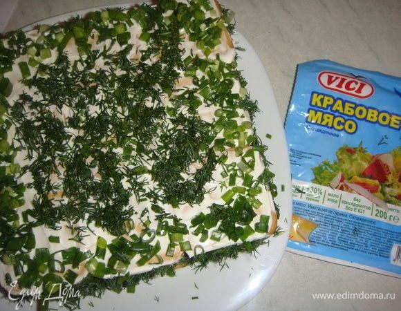 Верх и бока салата посыпаем зеленым луком и укропом. Украшаем салат яйцом и крабовым мясом. Отправляем на ночь в холодильник.
