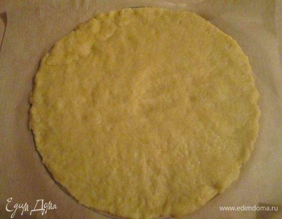 Пока миндальный корж остывает, займемся песочным.
На пекарской бумаге нарисовать окружность, используя донышко от формы. Бумагу хорошо смазать маслом и слегка присыпать мукой. Песочное тесто достать из холодильника, прямо на бумаге раскатать в лепешку размером с нарисованную вами окружность.