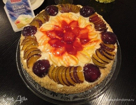 Верхний корж украсить оставшейся сливой и любимыми ягодами или фруктами. Желе для торта ТМ HAAS развести в соответствии с инструкцией на пакетике и залить торт. Бока украсить крошкой из печенья.