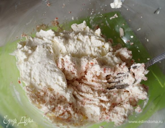 Половину взбитых сливок выложить к сырно-крабовой массе, слегка посолить и хорошо перемешать.