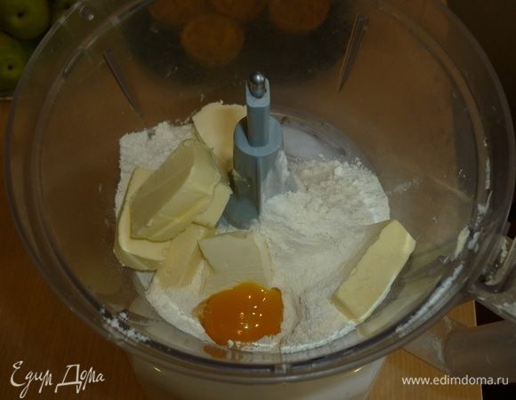 В комбайн сложить муку, добавить щепотку соли, желток и нарубить холодное масло. Прокрутить. Если тесто не собирается в комок, то добавить 1-2 ст. л. холодной воды. 