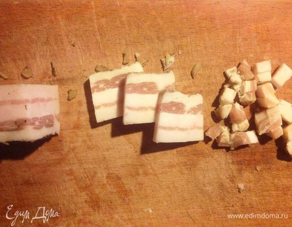 Самое время заняться секретным ингредиентом. Берем сало с мясными прослойками. Никакого подкопченного бекона! Обычное (лучше, конечно, домашнее) соленое сало с нежной шкуркой. Из специй только черный перец, чеснок, немного молотого кориандра. 
Отрезать мягкую шкурку и съесть с черным хлебушком — а что? Повар не должен быть голодным, а тут такие запахи. :)
Сало нарезать равномерно (это важно) мелкими квадратиками по 3-4 мм толщиной.