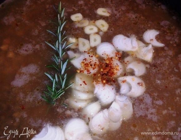 По истечении 20 минут в сковороду насыпаем рис и гречневую крупу. Добавляем порезанные лук, чеснок, и цельную веточку розмарина. Посолить, добавить молотый пеперончино (чили) накрыть крышкой и варить еще 20 минут.