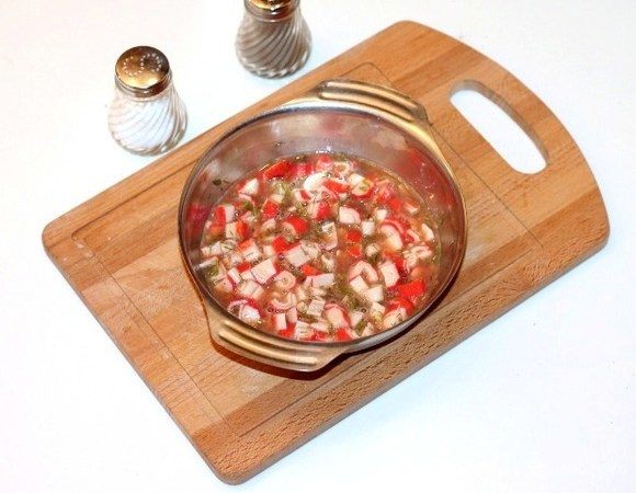 Смешать яичную смесь с крабовыми палочками.
