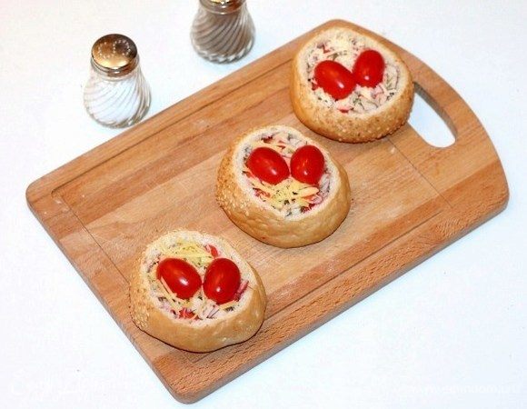 Заполнить булочки крабовой начинкой, посыпать тертым сыром и украсить помидорами черри. Положить булочки в форму для выпекания и поместить в горячую духовку, минут 20 при t 190-200°С. Как только верх зарумянится, булочки готовы!
