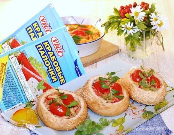 Если масса густая, добавьте 2-3 ст. л. сметаны или молоко и перемешайте. Выложите хлебную массу в форму для запекания (я не смазывала маслом) и посыпьте тертым сыром. Украсьте сверху половинками помидора черри и запекайте вместе с булочками до румяной корочки.
