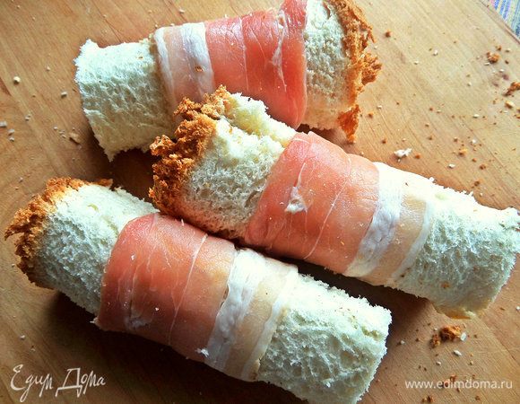 Свернуть рулетиком, обмотать полосками бекона.