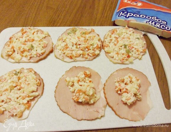 Выложить начинку на ломтики ветчины, распределить ее по всей поверхности.