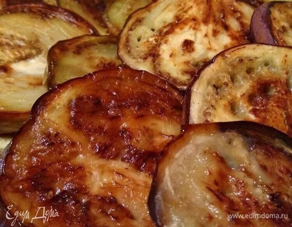 Баклажаны нужно нарезать кольцами и посыпать солью, чтобы убрать горечь. Когда выделится жидкость, обтираем их бумажным полотенцем. Выкладываем на противень и сбрызгиваем оливковым маслом. Теперь отправляем в разогретую до 180°С духовку и запекаем до мягкости минут 15-20.